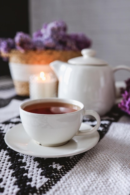 Uma xícara de chá com um bule em uma mesa com uma cesta de vime lilás festa do chá atmosférica photo