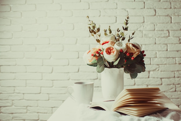 Uma xícara de chá preto, caderno e lindas flores na mesa. inspiração matinal para o planejamento do dia