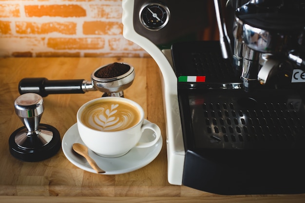 Uma xícara de latte art está pronta para servir na máquina de café expresso