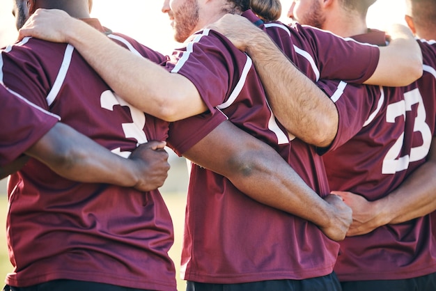 Umarmen Sie Sportler und Männer beim Spiel, um die Rugby-Mannschaft zu unterstützen oder sich für einen Wettbewerb zu solidarisieren. Fördern Sie die Motivation und die Teamarbeit von Männern oder Sportlern mit einer Gruppenzusammenarbeit und Freunden mit der Gemeinschaft auf einem Feld