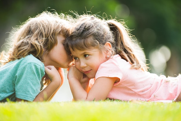 Umarmen und Küssen von Kindern Paar kleine reizende Kinder im Freien Kinder im Sommerpark Nahaufnahme Gesicht