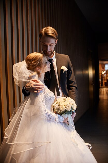 Umarmende und küssende Hochzeitspaare, der erste Tag des Lebens zusammen. Braut und Bräutigam nach Hochzeitszeremonie, schönes Paar liebt sich und das Umarmen