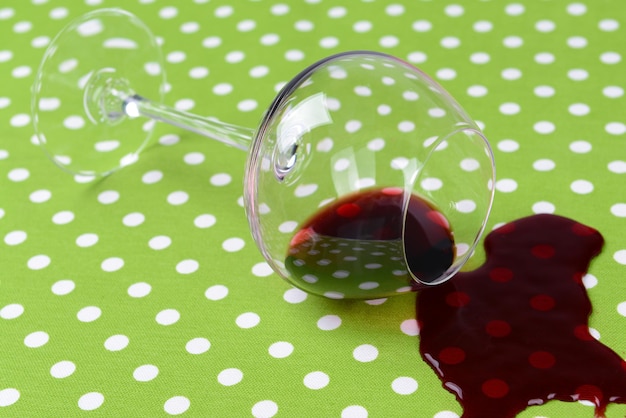 Umgestürztes Glas Wein auf dem Tisch in der Nähe