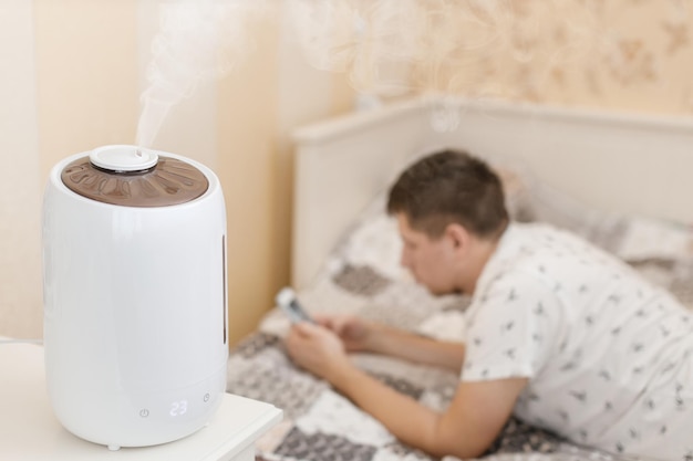 Foto umidificador espalhando vapor umidificação do ar seco no quarto de dormir no fundo jovem