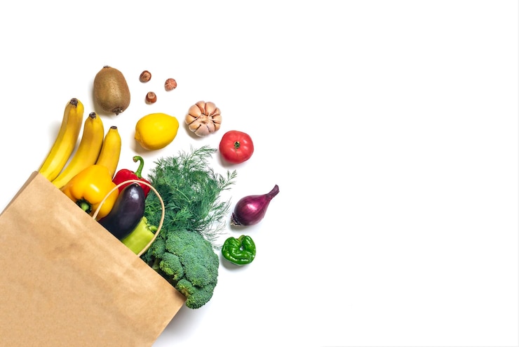 Foto umweltfreundliche papierladentasche mit rohem bio-grüngemüse isoliert auf weißem hintergrund flache ansicht von oben zero waste plastic free concept gesunde, saubere ernährung und detox-landwirtschaftskonzept