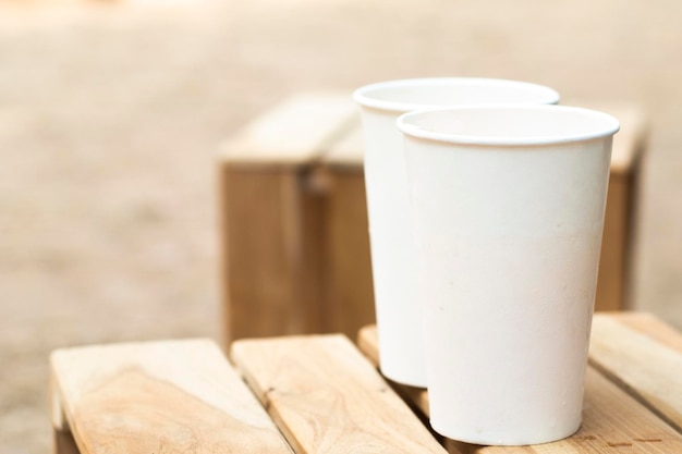 Umweltfreundliche Verpackung Einweg-Papierglas MockUp für Kaffee, Tee, Saft und Wasser, bereit für Design auf Holztisch, Vintage-Ton-Hintergrund Speichern Sie die Idee des Umweltkonzepts