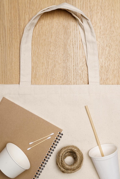 Umweltfreundliches Konzept Öko-Tasche mit Notebook-Pappbecher und Juteseil auf Holzhintergrund