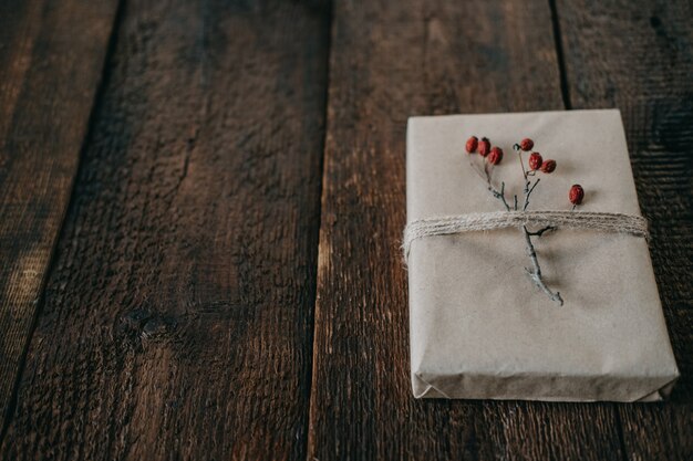 Umweltfreundliches nachhaltiges Zero-Waste-Weihnachtsgeschenk in Kraftpapier mit Garn und Beerendekor verpackt