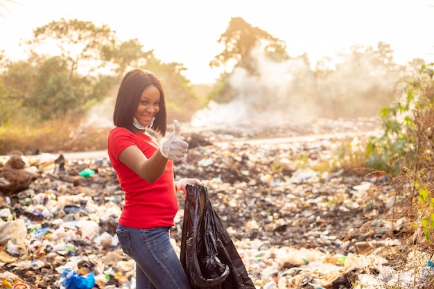 Umwelthygienekonzept Attraktive, vielfältige junge Frauen, die Abfälle in einen Müllsack recyceln