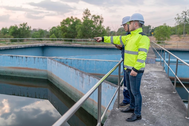 Umweltingenieure arbeiten in Abwasserreinigungsanlagen Wasserversorgungstechniker arbeiten in einer Wasserrecyclinganlage für die Wiederverwendung Techniker und Ingenieure besprechen die Zusammenarbeit