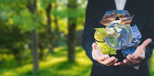 Foto umweltkonzept geschäftsmann hält und zeigt global mit öko-symbol geschäftsmann mit globalem und recycelbarem holz himmel wasser umweltschutz industrie umweltschutz nachhaltige zukunft