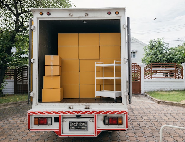 Foto umzugstag weißer lieferwagen und offener kofferraum mit kartons im freien logistikdienst für hausumzüge transport von gegenständen konzept für den umzugstag