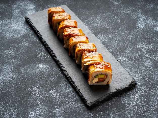 Unagi-Sushi-Rollen Sushi mit geräuchertem Aal auf schwarzem Hintergrund Japanische Küche