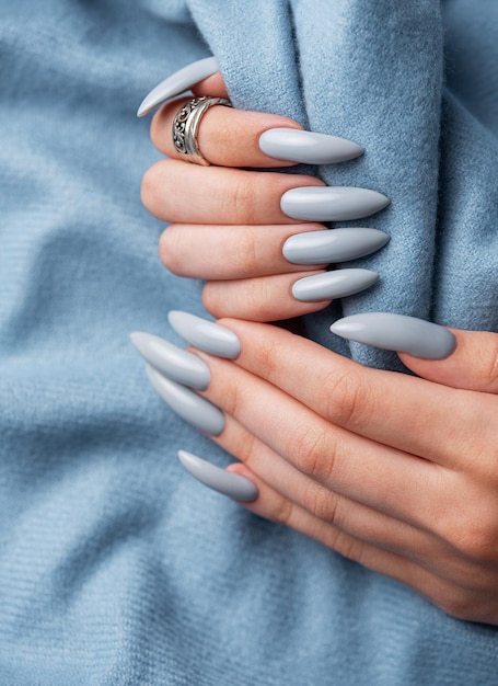 Las uñas de manicura azules con una bufanda azul