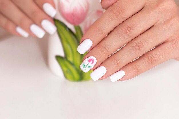 Las uñas de una mujer con un diseño floral en ellas