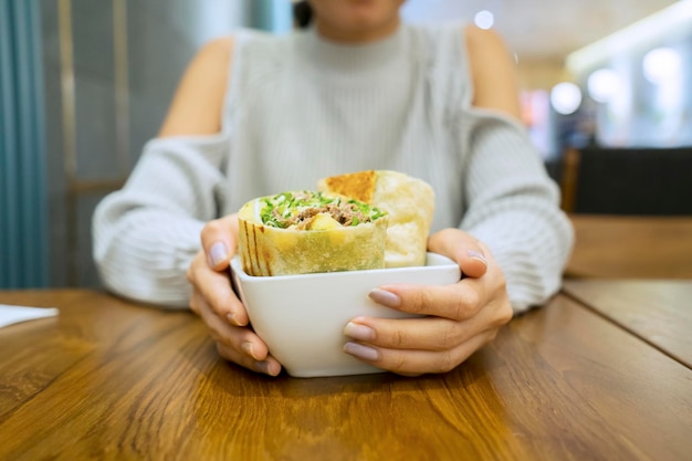 Unbekannte Frau isst Burrito im Restaurant