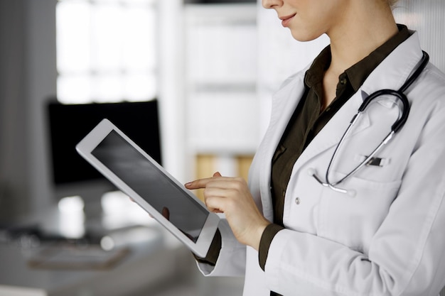Unbekannte Ärztin mit Tablet-Computer in der Klinik. Perfekte medizinische Versorgung im Krankenhaus. Medizin-Konzept.