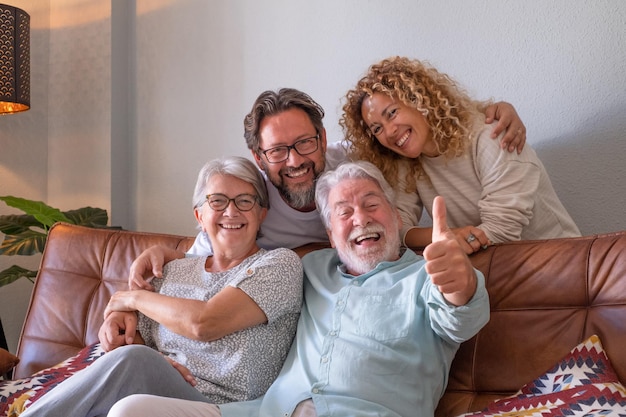 Unbeschwerte Gruppe von Mehrgenerationenfamilien, die zu Hause auf dem Sofa sitzen und sich entspannen, um Zeit miteinander zu verbringen
