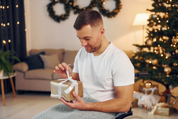 Unboxing-Voreinstellung Das neue Jahr steht vor der Tür Behinderter Mann im Rollstuhl ist zu Hause