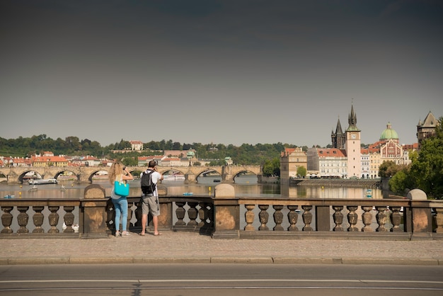 Undefinierte reisende mit rucksäcken, die fotos von prag an der legionsbrücke tschechien machen