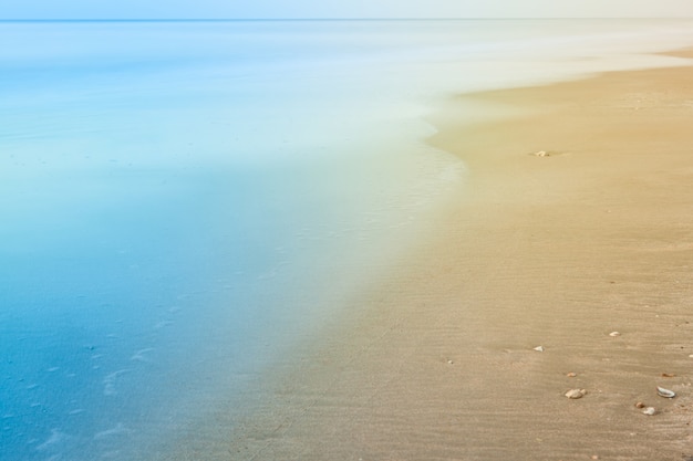 Undeutlicher Hintergrund von Strand- und Meereswellen mit Weinlese färben Art.