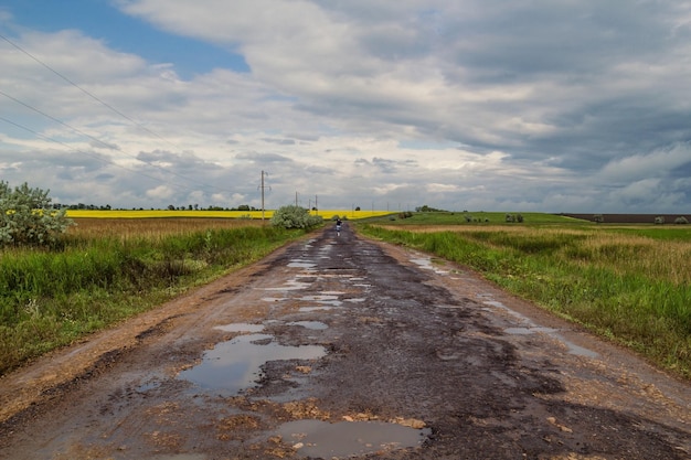 Unebene Straße im Feldlandschaftsfoto