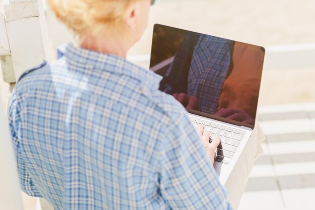 Foto unerkennbare ältere frau benutzt laptop für fernunterricht im freien