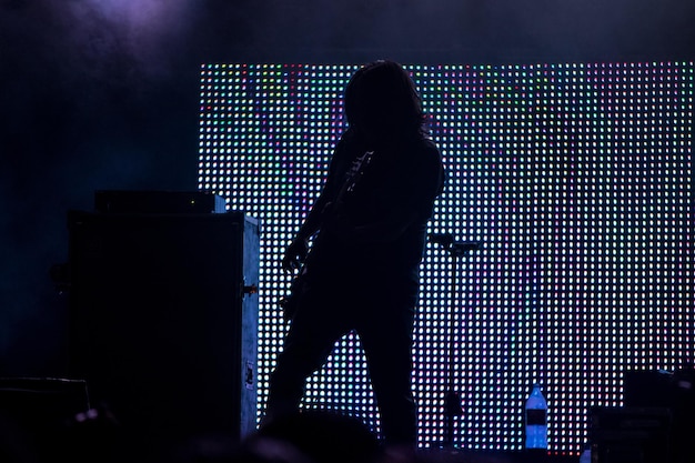 Foto unerkennbare band-silhouette sicht auf die bühne während eines rockkonzerts mit musikinstrumenten und szene
