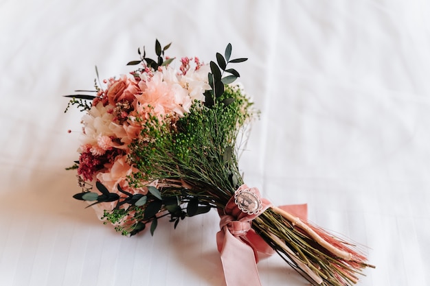 Unerkennbare Braut, die an ihrem Hochzeitstag ihren Blumenstrauß hält