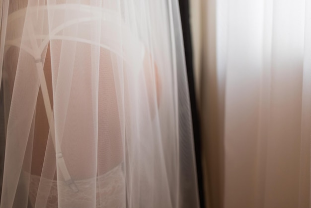 Unerkennbare Braut in einem Seidengewand mit schönen schlanken Beinen zieht Strümpfe an Vorbereitung des Hochzeitsmorgens Dressing Dessous Boudoir