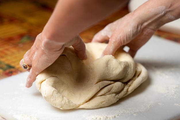 Unerkennbare Frau knetet Teig Teig für Knödel, Knödel, Kuchen