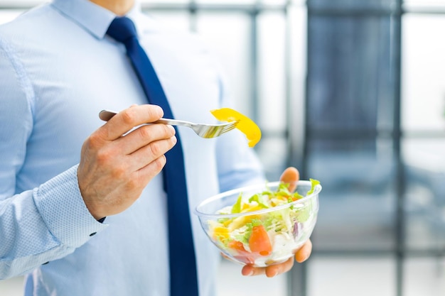 Unerkennbarer Geschäftsmann isst einen Gemüsesalat zum Mittagessen gesundes und Lifestyle-Konzept