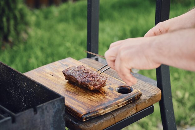 Foto unerkennbarer mann nimmt saftiges steak aus dem grill