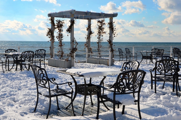 Unerwarteter Schnee zu Weihnachten und leere Cafétische am Meer, Schnee an der Küste