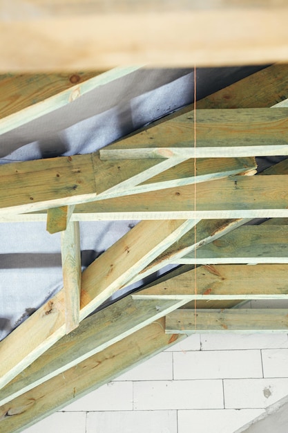 Foto unfertiger holzdachstuhl im dachgeschoss mit dampfsperre nahaufnahme blick auf holzsparren und balken