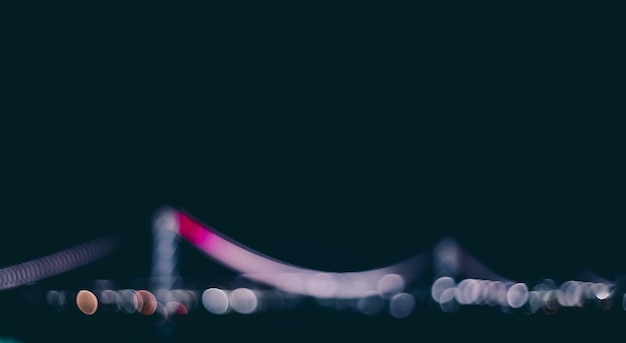 Unfokussiertes Bild einer beleuchteten Brücke vor klarem Himmel bei Nacht