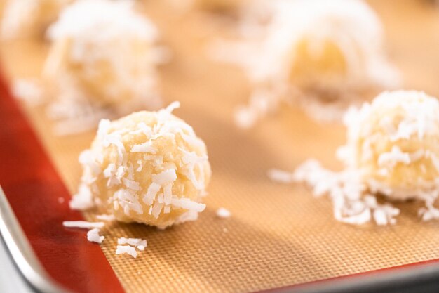 Ungebackene Teigschaufeln auf dem Backblech, um Kokoskekse zu backen.