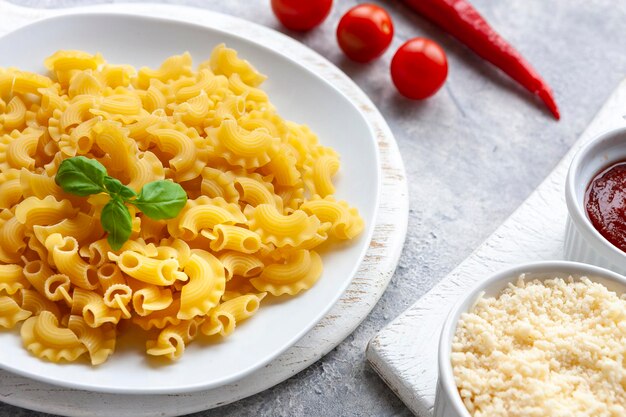 Ungekochte Creste di Gallo-Pasta und Zutaten zum Kochen