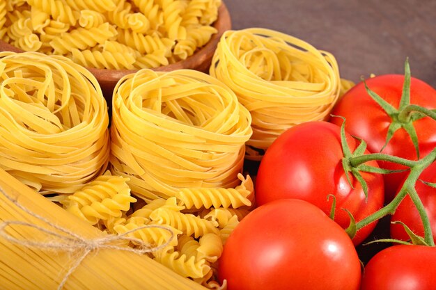 Ungekochte italienische Pasta und reife Tomaten Zweig hautnah