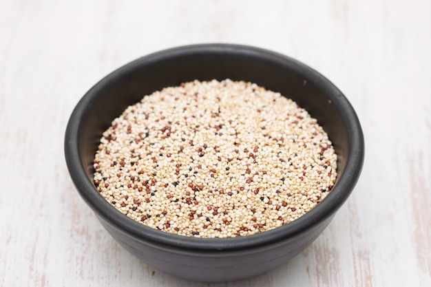 Ungekochte Quinoa in schwarzer Schüssel