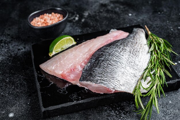 Ungekochte rohe Dorado-Meerbrasse-Fischfilets schwarzer Hintergrund Draufsicht