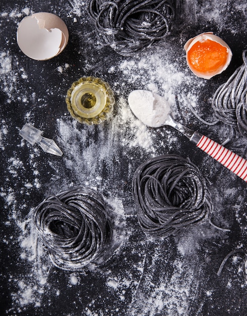 Ungekochte schwarze Pasta und Zutaten für hausgemachte Spaghetti