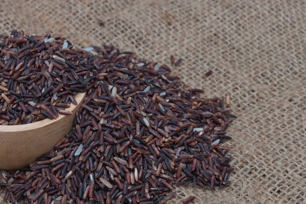 Ungekochter brauner Reis (Riceberry) auf Sack.