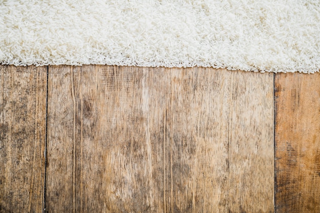 Ungekochter Reis und hölzerner Beschaffenheitshintergrund