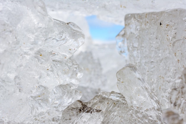 Ungewöhnliche Formen und Texturen von Eiskristallen schließen flachen Dof mit Kopienraum aus. Winter- und Frühlingslandschaft.