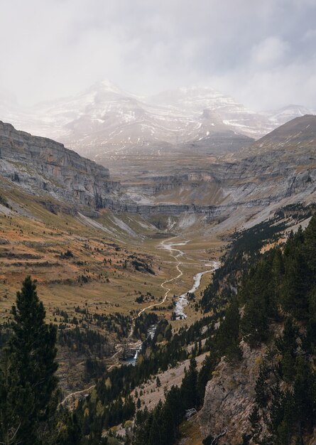 Unglaubliche Aussicht auf ein Tal mit einem Fluss und schneebedeckten Bergen