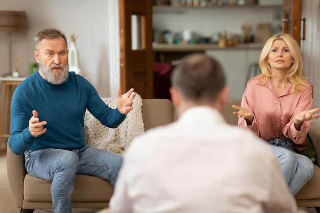 Unglückliche Ehepartner, die eine Ehetherapiesitzung mit einem professionellen Psychologen im Haus haben