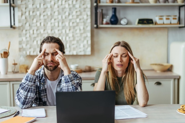 Unglückliche junge europäische Paare haben Stress, denken und leiden unter Kopfschmerzen, Rechnungen und Steuern bezahlen