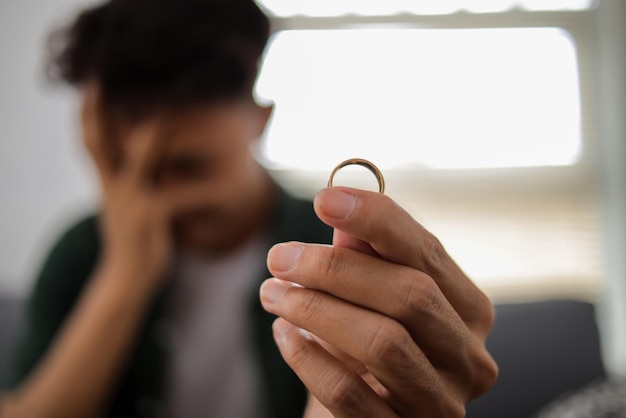 Unglücklicher Mann beschließt, den Hochzeitsring zu entfernen und Scheidungsurkunden vorzubereiten