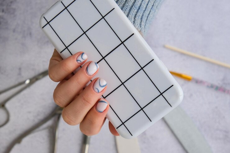 Foto unhas femininas azuis elegantes segurando telefone móvel tecnologia de smartphone mídia social elegante moderno